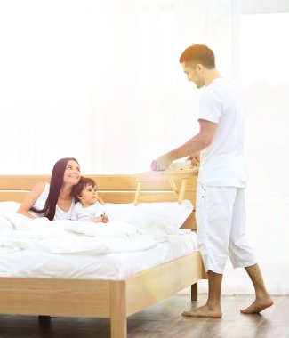 Gülümseyen aile kahvaltı yapıyor.