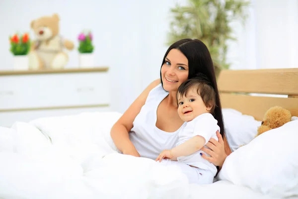 Mother and baby in diaper playing in sunny bedroom — Stock Photo, Image