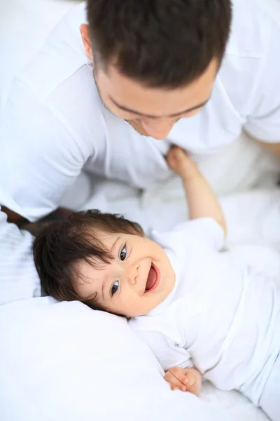 Junge liegt neben seinem Vater auf dem Bett — Stockfoto