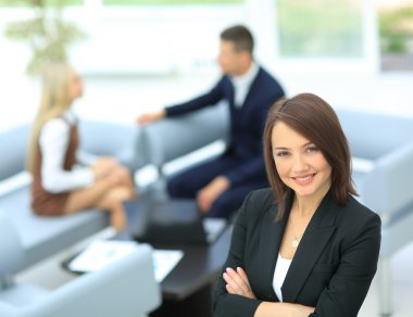 Genç iş kadını ile onun Meslektaşlarımız arka planda duran bir