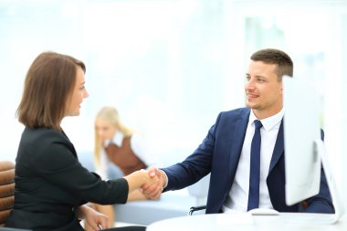 Toplantı salonunda iş ortakları el sıkışıyor.