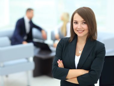 Başarılı bir iş kadını arkasında personeliyle duruyor.