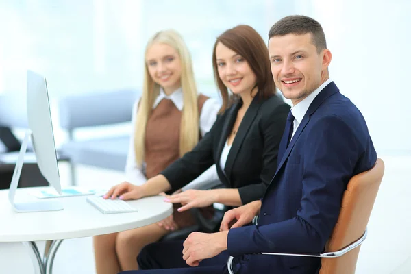 Empresarios que se reúnen alrededor de la mesa en la oficina moderna —  Fotos de Stock