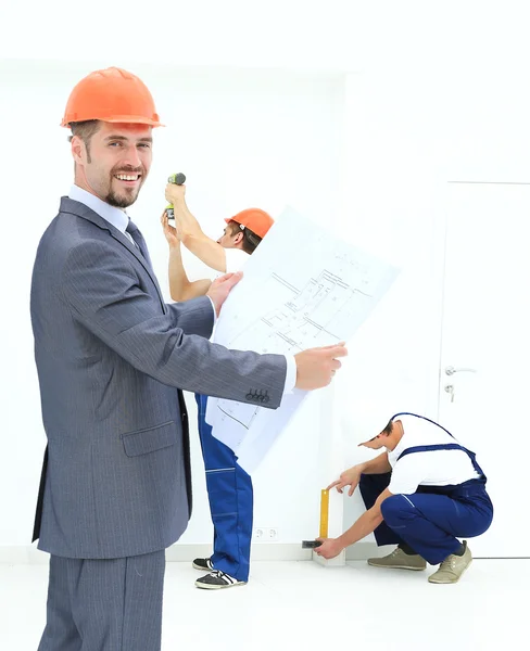 Ingegnere che studia le cianografie sullo sfondo di una squadra b — Foto Stock