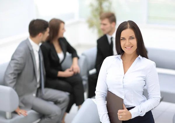 Успішна бізнес-леді стоїть зі своїм персоналом на задньому плані — стокове фото