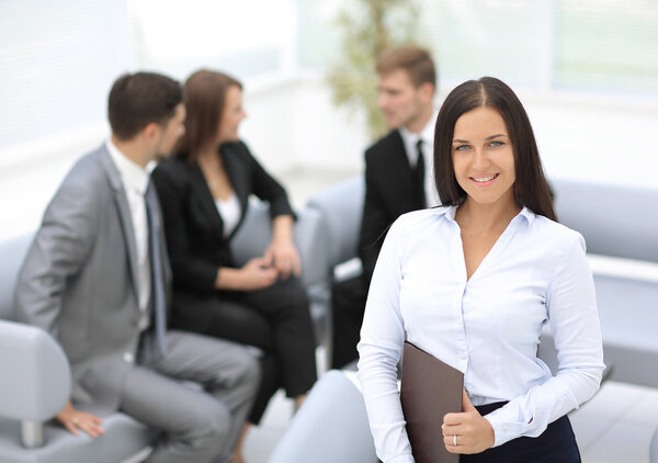 Successful business woman standing with her staff in background