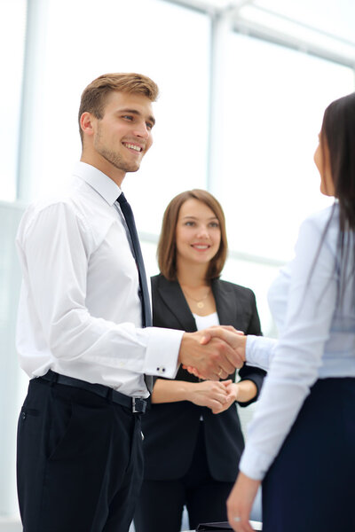 Happy business partners shaking hands in an office