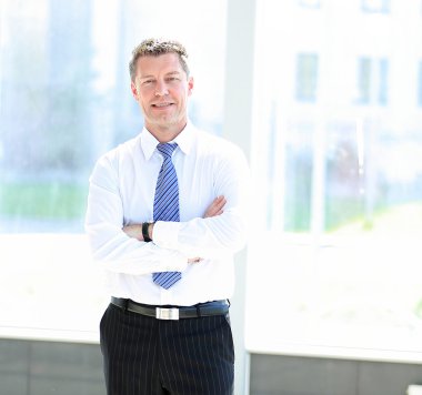 Modern bir ofiste mutlu gülümseyen işadamı portresi