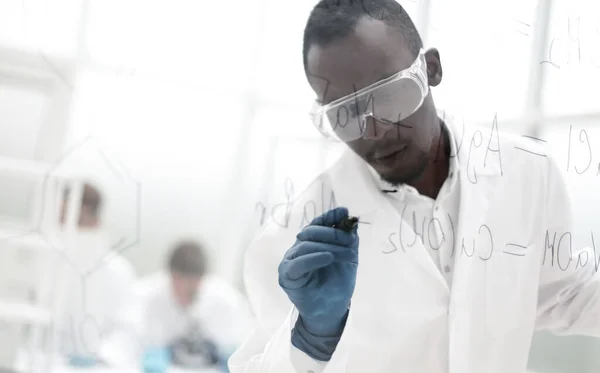 Wissenschaftler schreibt chemische Formel auf ein Glasbrett — Stockfoto