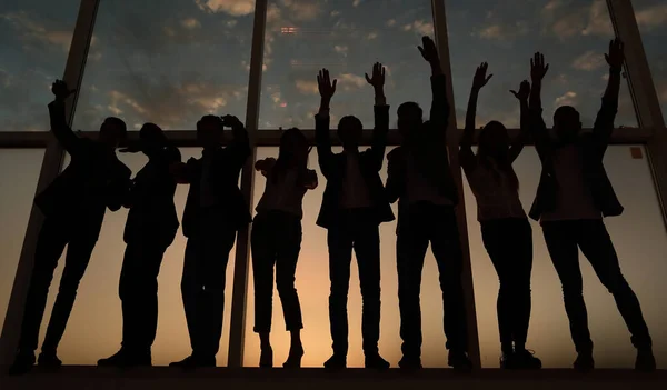 Silueta de un grupo de empresarios levantando la mano — Foto de Stock