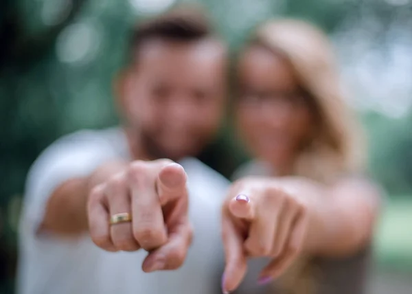 Feliz casal de pé no parque e apontando para você. — Fotografia de Stock