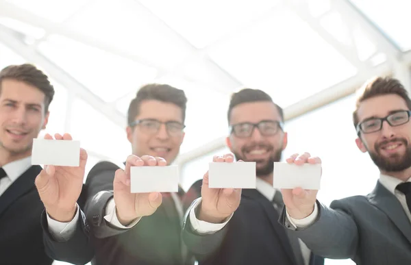 Quatre jeunes hommes d'affaires montrant leur carte de visite — Photo