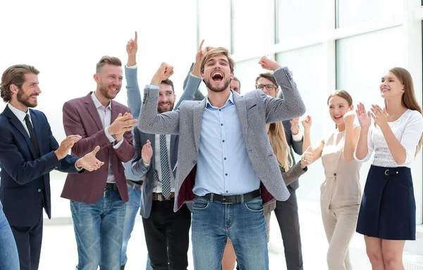 Heureux jeune homme d'affaires debout devant son équipe d'affaires. — Photo