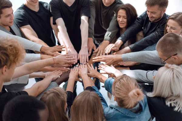 Gruppe unterschiedlicher Menschen, die sich im Kreis die Hände reichen. — Stockfoto