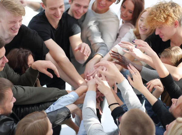 Gruppe unterschiedlicher Menschen, die sich im Kreis die Hände reichen. — Stockfoto