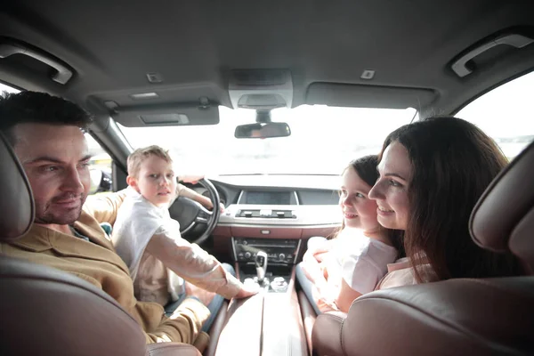 cheerful family sitting in the car