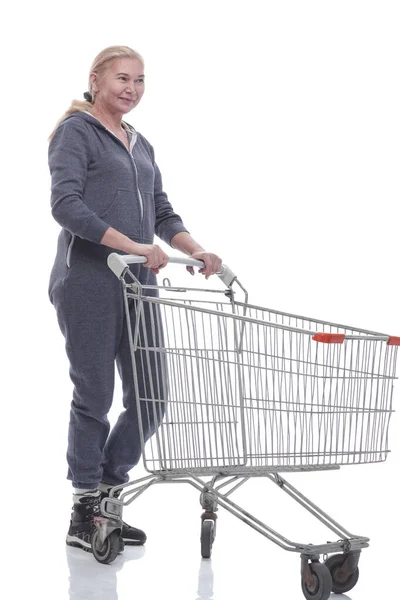 In full growth. smiling woman with shopping cart pointing at you — Stock Photo, Image