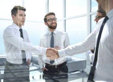 İş yerindeki iş adamları el sıkışır.