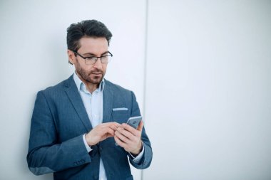 Akıllı telefonunda SMS yazan kendine güvenen iş adamı