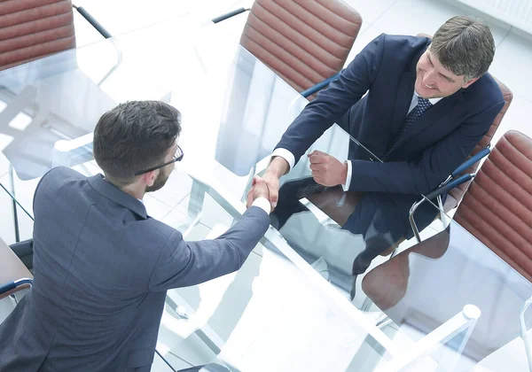 Handslag över bordet med finansiella partner — Stockfoto