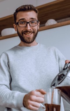 Kapat. Bir adam kendine sabah kahvesi dolduruyor.