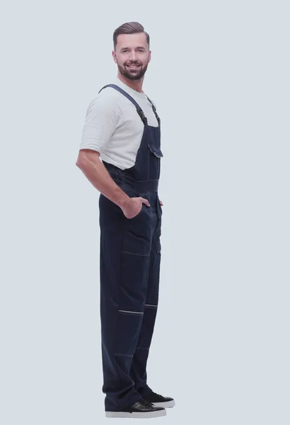Side view. smiling man in overalls looking forward to copy space — Stock Photo, Image