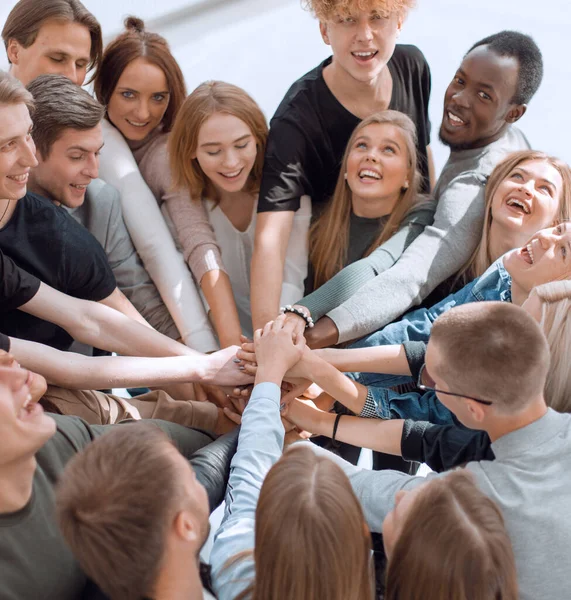 Gruppe unterschiedlicher Menschen, die sich im Kreis die Hände reichen. — Stockfoto