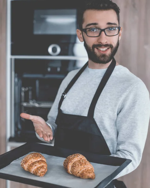 Glimlachende man met een dienblad verse croissants — Stockfoto