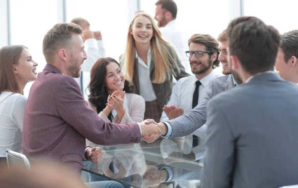 Sonrientes socios de negocios estrechando la mano, al aplauso del equipo de negocios — Foto de Stock