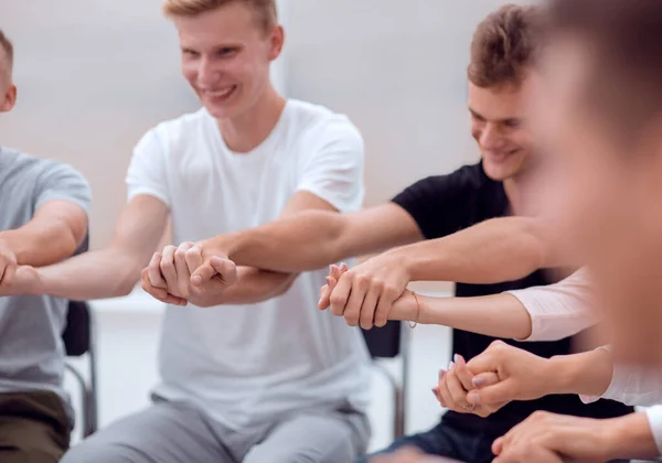 Крупний план. різноманітні молоді люди беруть один одного за руки — стокове фото