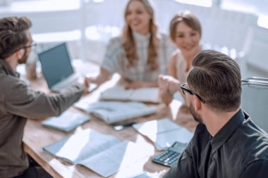 İş adamı iş ortaklarının el sıkışmasına bakıyor