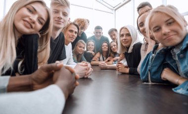 Kapat. Uzun bir masada oturan büyük bir arkadaş grubu.