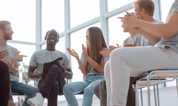 Orador sonriente sentado en un círculo de jóvenes — Foto de Stock