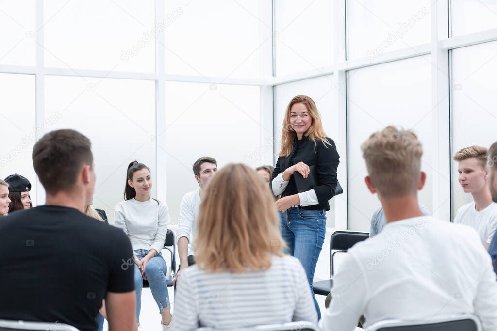 young woman standing in a circle of her colleagues.