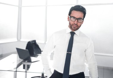 Geniş bir ofiste kendine güvenen bir iş adamı