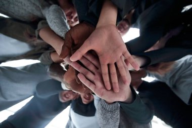 Alt manzara. Bir grup mutlu genç insan ellerinden bir kule yapıyorlar. .