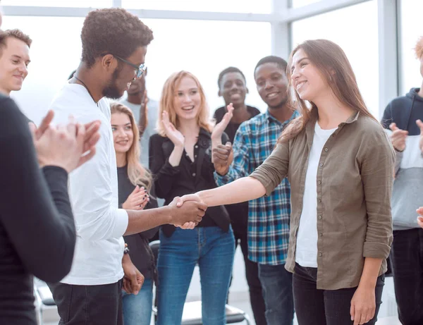 Grupp glada ungdomar gratulerar sin kollega — Stockfoto