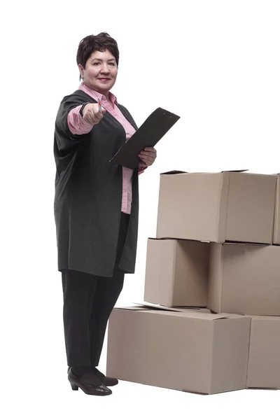 Donna con un blocco appunti in piedi vicino a scatole di cartone — Foto Stock