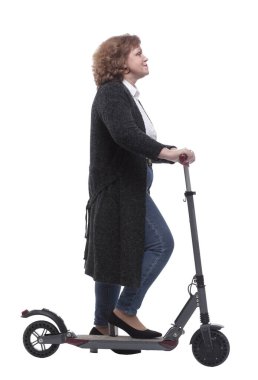 Yan görünüş. Elektrikli scooterlı kendine güvenen bir kadın kameraya bakıyor.