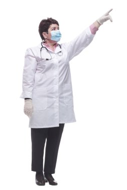 Tam gelişim. Koruyucu maskeli bir doktor beyaz bir duvarda ilan okuyor..