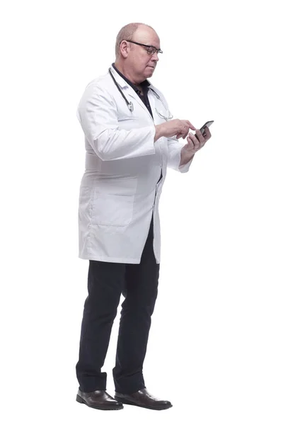 В полном росте. Зрелый доктор, читающий сообщение на своем смартфоне — стоковое фото