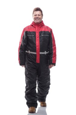 Kışın yalıtılmış tulumlu bir adam ileri doğru yürüyor.