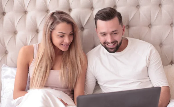 Jovem casal navegando seu favorito vidio em seu laptop — Fotografia de Stock