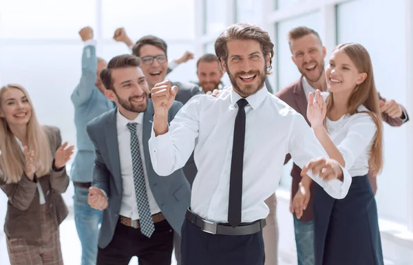 Gelukkige jonge zakenman staan voor zijn business team — Stockfoto