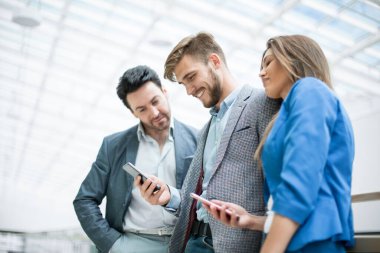 Kapat. İş arkadaşları akıllı telefonlardan mesaj okuyor.