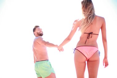 Plajda mayo giyen çekici fit çift el ele tutuşuyor..