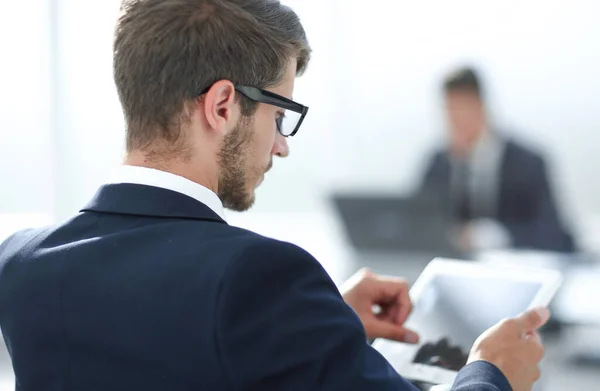 Empresário close-up concentrado assistindo em toque pad enquanto sentado no escritório — Fotografia de Stock