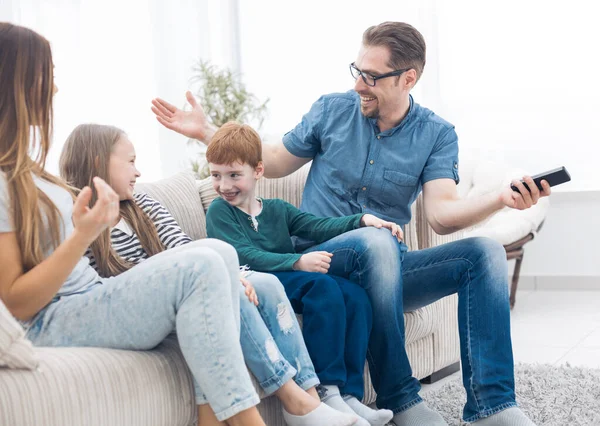 Veselá rodina sedí na gauči v obývacím pokoji — Stock fotografie
