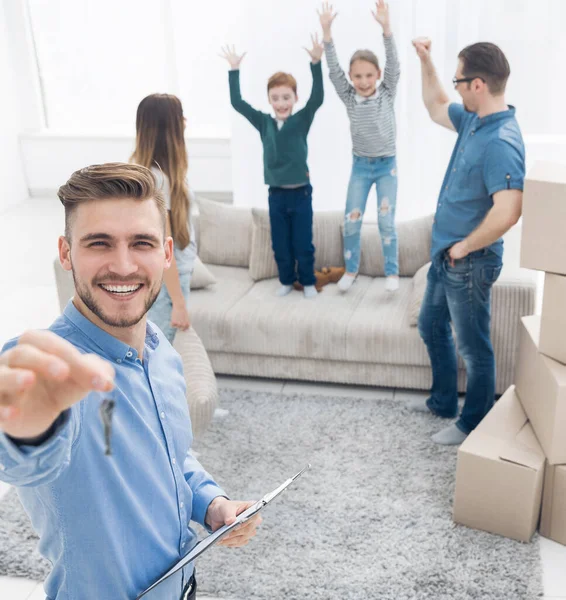 Sorrindo corretor de imóveis com área de transferência mostrando chaves para novo apartamento — Fotografia de Stock