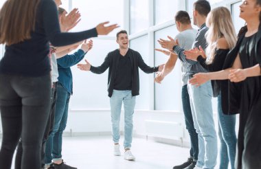 Bir grup mutlu çalışan meslektaşlarını tebrik ediyor.